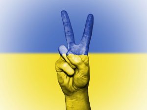 ukrajinská vlajka a ruka v gestu míru